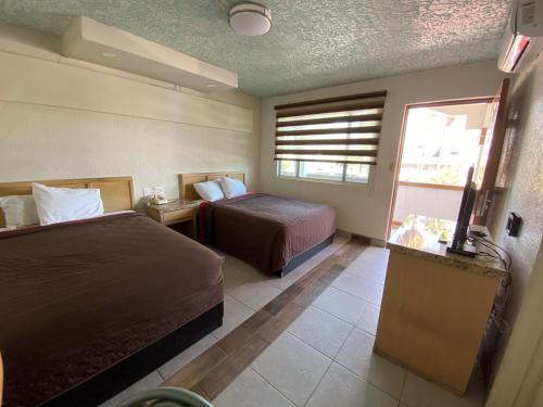 a hotel room with two beds and a television at Motel Reno in Tijuana