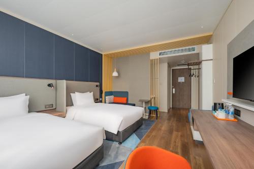 a hotel room with two beds and a flat screen tv at Holiday Inn Express Taiyuan High Tech Zone by IHG in Taiyuan