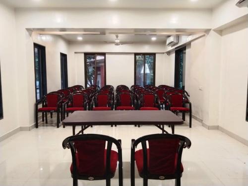 a conference room with red chairs and a table at Cocorico Beach Resort in Dapoli