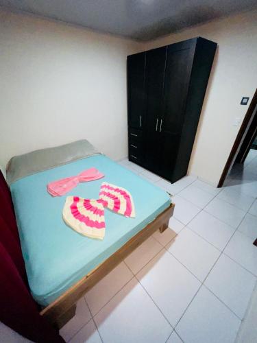 a small bedroom with a bed with slippers on it at Around Juan Santa María in Alajuela City