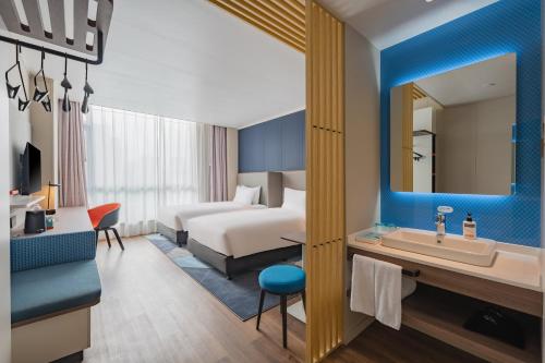 太原市にあるHoliday Inn Express Taiyuan High Tech Zone, an IHG Hotelのベッドとシンク付きのホテルルーム