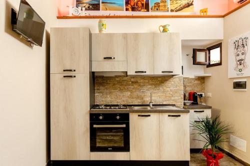 una cucina con armadi bianchi e piano cottura di La casa di Adina a Agrigento