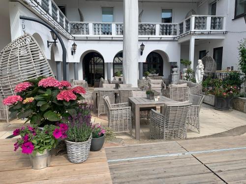 an outdoor patio with tables and chairs and flowers at Boutiquehotel Goldhahn Bio Sport & Wellness in Aalen