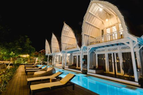 a resort with a swimming pool at night at Mambo Beach Resort in Nusa Penida