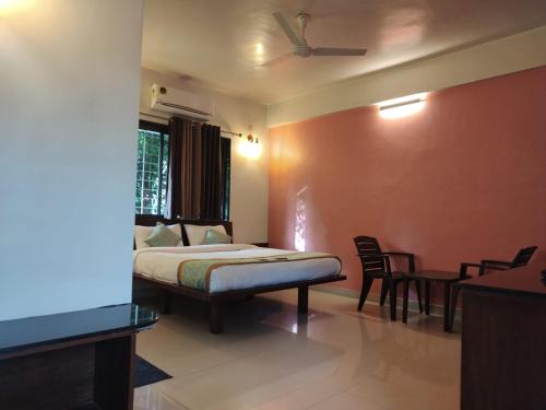 a bedroom with a bed and a table and chairs at Cocorico Beach Resort in Dapoli