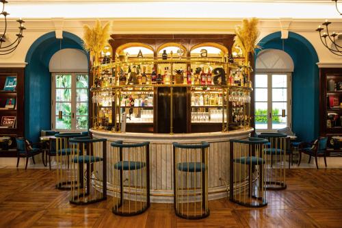 a bar in a room with blue walls and stools at Villa Agrippina Gran Meliá – The Leading Hotels of the World in Rome