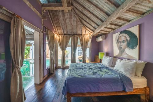 1 dormitorio con 1 cama y una pintura de una mujer en Villa West - Charming 2 bdr villa in Oberoi - PERFECT LOCATION!, en Seminyak