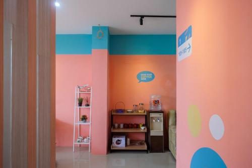 a room with a colorful wall with a shelf at Sans Hotel Tiga Putri Semarang by RedDoorz in Semarang