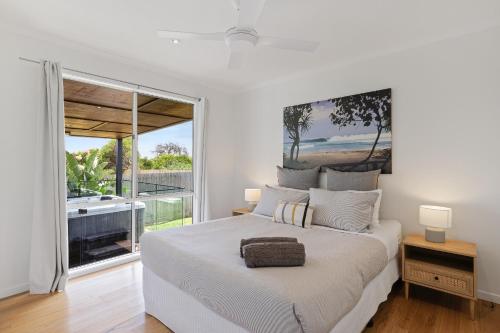 a white bedroom with a large bed and a large window at Island Getaway Cape Woolamai in Cape Woolamai