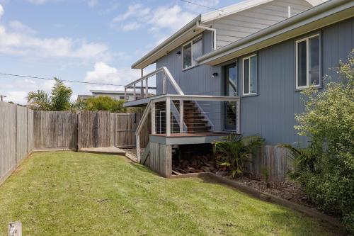 a house with a wooden fence next to a yard at Island Getaway Cape Woolamai in Cape Woolamai