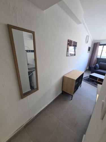 een woonkamer met een spiegel en een tafel bij Beau Studio Hypercentre Saint Denis in Saint-Denis