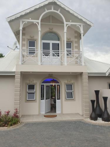 a house with a balcony on top of it at Caribbean Estates Villa Raiya- First choice !!! 4 bedrooms with ensuite bathrooms in Port Edward