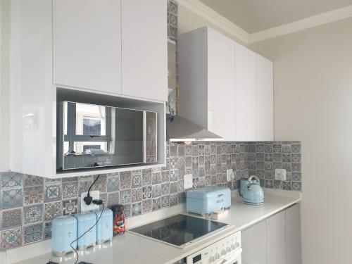 uma cozinha com armários brancos e um lavatório em Caribbean Estates Villa Raiya- Recently Developed! 4 bedroom unit em Port Edward