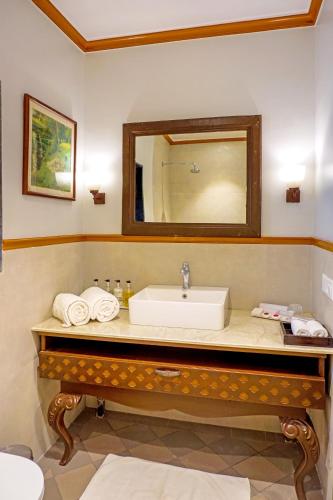 a bathroom with a sink and a mirror at Citrus Chambers Mahabaleshwar in Mahabaleshwar