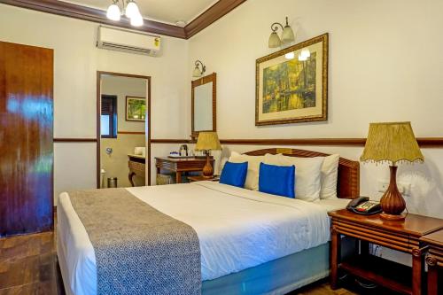 a bedroom with a bed and a desk with a telephone at Citrus Chambers Mahabaleshwar in Mahabaleshwar