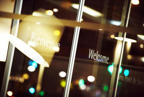 a window with a sign that says berkhamota and welcome at Campanile Paris Ouest - Pont de Suresnes in Suresnes