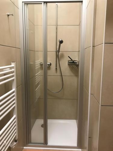 La salle de bains est pourvue d'une douche avec une porte en verre. dans l'établissement Gite du pèlerin-Chalet de montagne, à Orsières