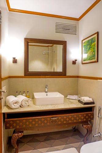a bathroom with a sink and a mirror at Citrus Chambers Mahabaleshwar in Mahabaleshwar