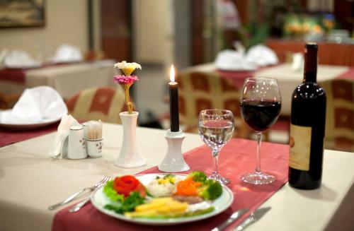 een tafel met een bord eten en een fles wijn bij SEFA HOTEL 1 ÇORLU in Corlu