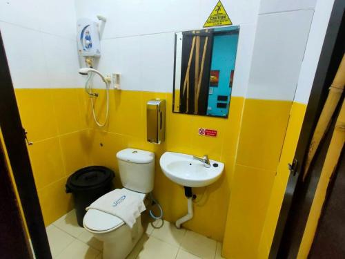 a bathroom with a toilet and a sink at Holiday Dive Inn in Semporna