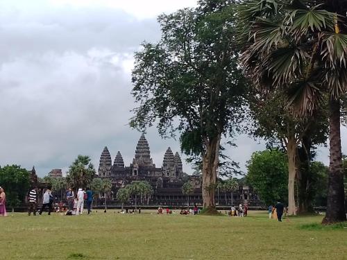a group of people standing in a park in front of a building at Realkhom Homestay in Siem Reap