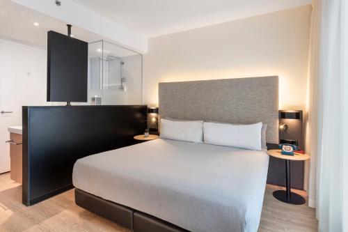 a bedroom with a large bed and a table at INNSiDE by Meliá Amsterdam in Amsterdam