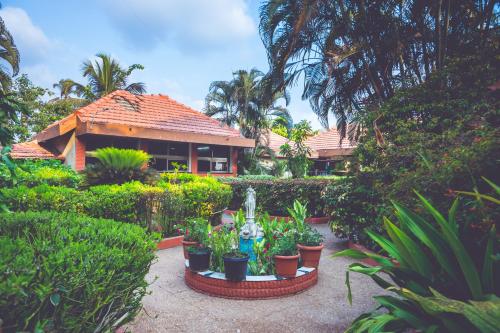 a house with a lot of plants in front of it at Malpe Sea Front Cottages in Udupi