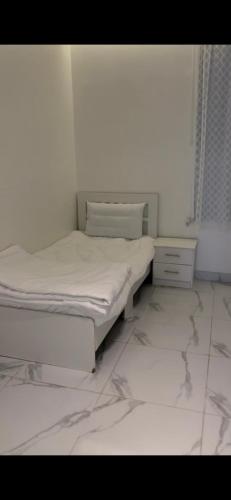 a bedroom with two beds and a tiled floor at Altaraf Resort in Al Shafa