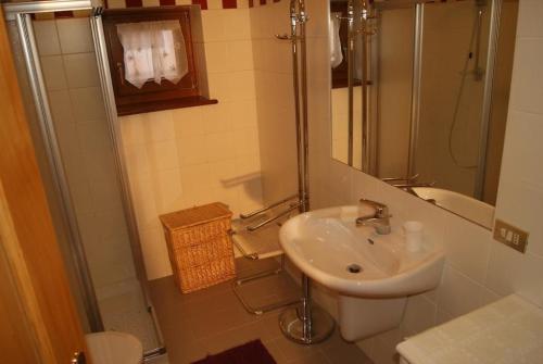 uma casa de banho com um lavatório, um chuveiro e um WC. em Residence Margherita em Moena