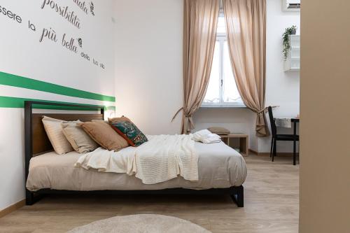 - une chambre dotée d'un lit avec une bande verte sur le mur dans l'établissement CASA SAN PAOLO, à Turin