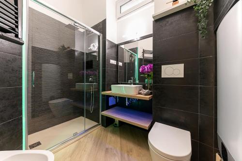 une salle de bain avec toilettes et douche en verre dans l'établissement CASA SAN PAOLO, à Turin