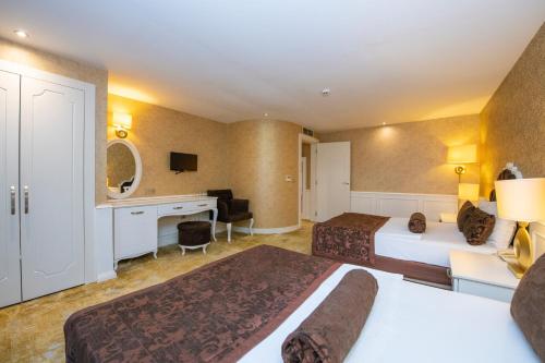 a hotel room with two beds and a desk at Han Deluxe Hotel in Oludeniz
