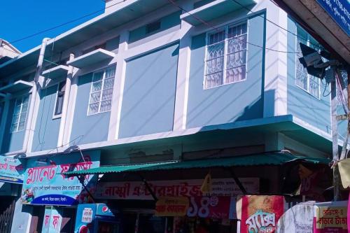 a blue and white building with windows on a street at Ashiana Serviced Apartment in Sylhet