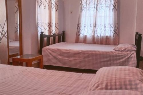 1 dormitorio con 2 camas, espejo y espejo en Ashiana Serviced Apartment en Sylhet