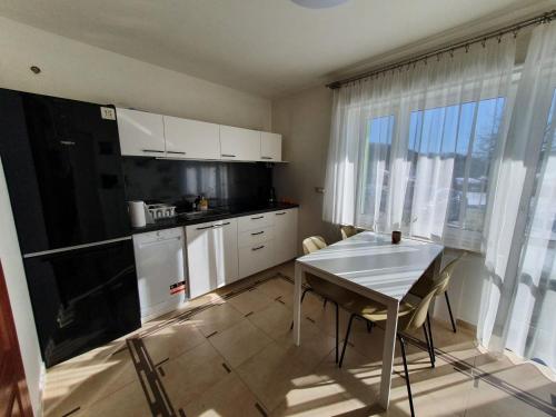 eine Küche mit weißen Schränken und einem Tisch mit Stühlen in der Unterkunft Apartament Tadeusz 2 B in Krynica-Zdrój