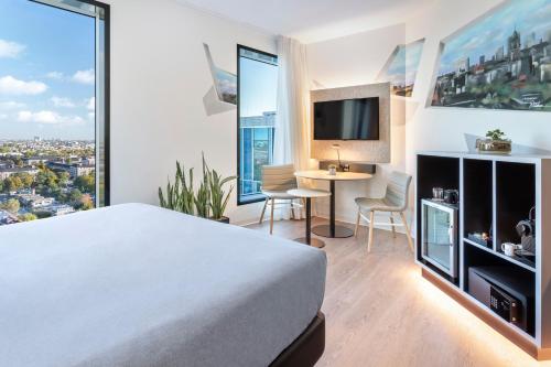 a hotel room with a bed and a desk and a tv at INNSiDE by Meliá Amsterdam in Amsterdam
