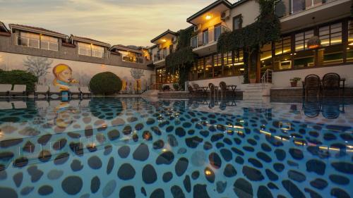 a swimming pool with blue water in front of a building at Han Deluxe Hotel in Oludeniz
