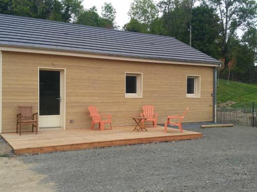 une terrasse avec deux chaises, une table et deux chaises dans l'établissement Les Gites de Vulcain, à Rochefort-Montagne