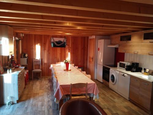 una cocina con mesa con sillas y una cocina con en Les Gites de Vulcain, en Rochefort-Montagne