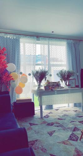 a living room with a table in front of a window at Altaraf Resort in Al Shafa