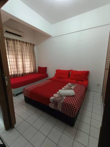 a bedroom with a red bed and a couch at Port Dickson Seaview Homestay in Port Dickson