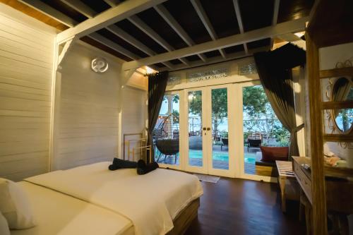 a bedroom with a bed and a view of a pool at Mambo Beach Resort in Nusa Penida