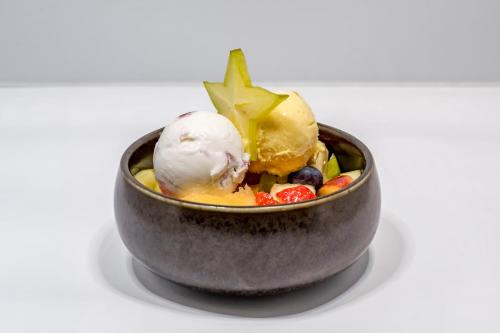 a bowl of food with ice cream and fruit at Hotel Grauer Bär in Sölden