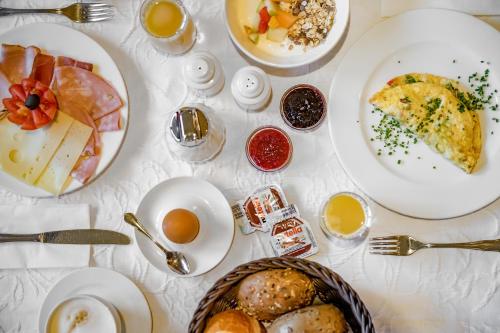 a white table with plates of food on it at Hotel Grauer Bär in Sölden