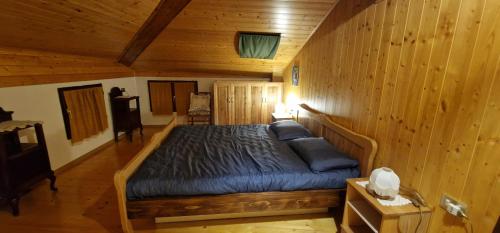 ein Schlafzimmer mit einem Bett in einer Holzhütte in der Unterkunft Casa della Rosina in Bresimo