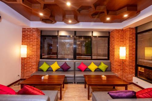 a living room with a couch with colorful pillows at Sunshine Boutique Hotel in Kathmandu