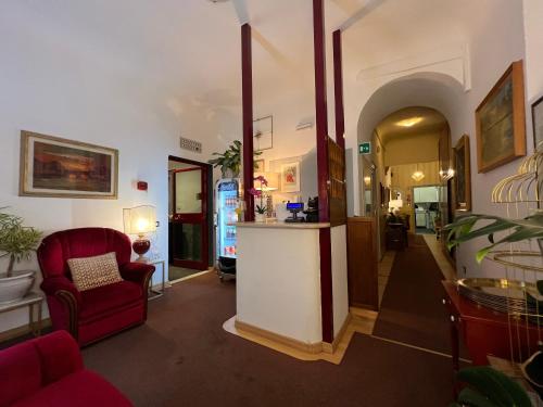 a lobby with a bar and a red chair at Hotel Villani in Florence