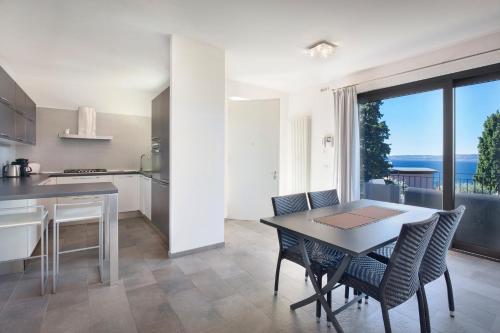 eine Küche und ein Esszimmer mit einem Tisch und Stühlen in der Unterkunft Villa Loncrino, First Floor Apartment in Torri del Benaco