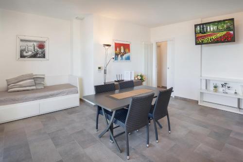 Cette chambre comprend une table, des chaises et un lit. dans l'établissement Villa Loncrino, First Floor Apartment, à Torri del Benaco
