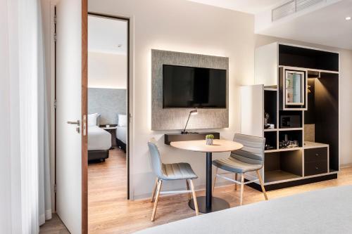 a hotel room with a table and chairs and a bed at INNSiDE by Meliá Amsterdam in Amsterdam
